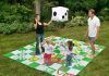 Jugar al parchís y a la oca sobre el césped del jardín
