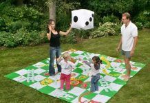 Jugar al parchís y a la oca sobre el césped del jardín