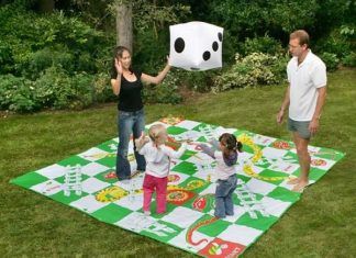 Jugar al parchís y a la oca sobre el césped del jardín