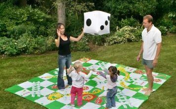 Jugar al parchís y a la oca sobre el césped del jardín