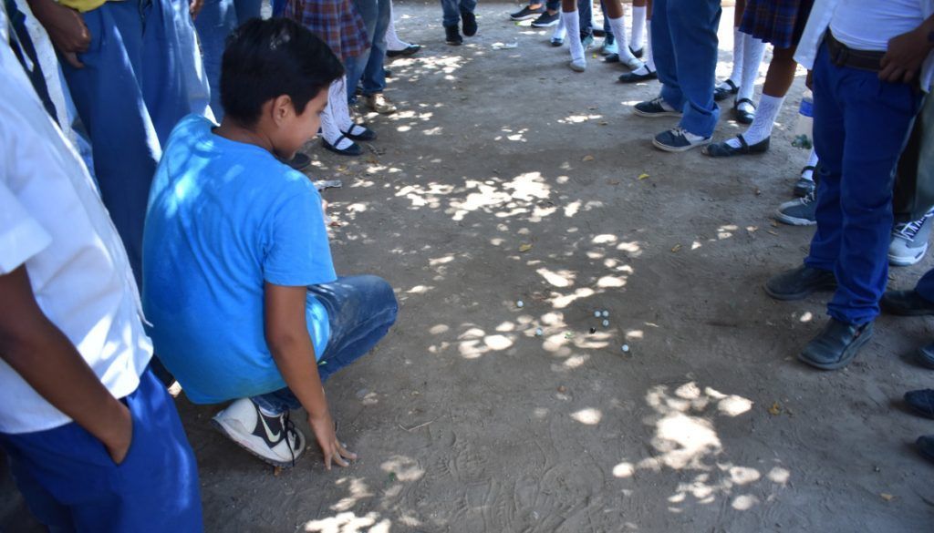 Acción del juego de los cincos o las canicas