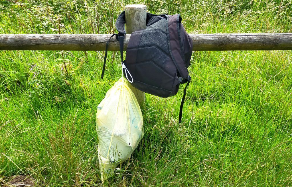 Al final de la caminata, la bolsa al contenedor de residuos